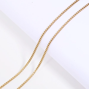 Detailed view of vacuum plated gold stainless steel box chain necklace with metallic luster