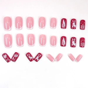 Christmas press-on nails with red snowflakes, reindeer, and French tip holiday designs
