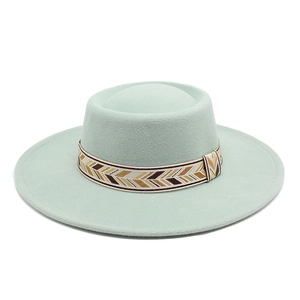 Close-up of flat brim wool felt hat featuring a geometric woven band in mint green