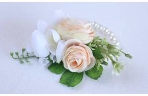 Detail of champagne artificial rose wrist corsage with white pearls for weddings