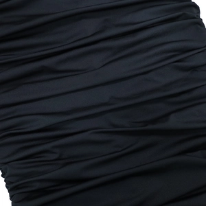 Close-up detail of the black ruched stretch fabric and pleated texture of the bodycon dress