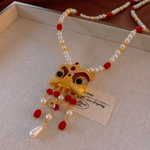 Vue détaillée du pendentif lion serti avec perles et pompons de pièces anciennes