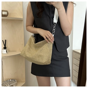 Close-up of beige woven tote bag showing detailed openwork mesh texture and silver chain