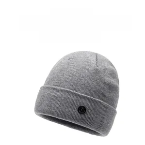 Close-up of light gray winter knit beanie showing detailed ribbed texture and side patch