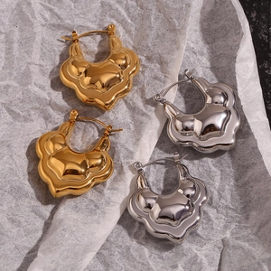 Detailed close-up of hollow layered lotus earrings in polished gold and silver finishes