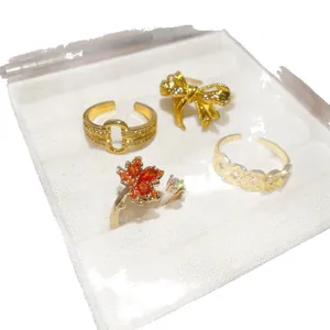 Set of four 18k gold plated open rings featuring maple leaf and bowknot designs with zircons
