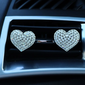 Sparkling rhinestone heart-shaped car air vent clips installed on dashboard vents