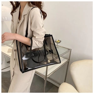 Detailed side view of smoke gray transparent PVC tote bag with black trim and leather straps