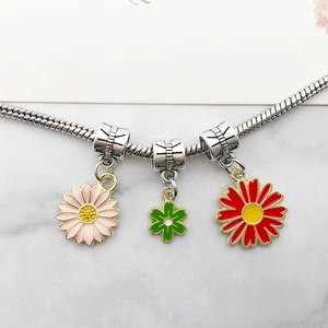 Daisy flower alloy pendants in pink green and red on a silver snake chain bracelet