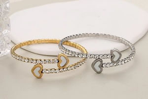 Macro detail of heart-shaped crystal bangles with shell inlay and cubic zirconia studs