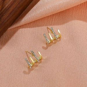 French vintage gold earrings with four rows and micro-pave crystals on wooden texture