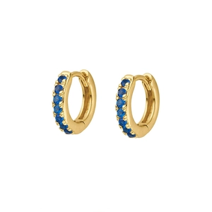 Detail view of gold hoop earrings featuring a row of micro-pave blue cubic zirconia stones