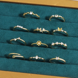 11er-Set goldene Ringe mit Zirkonia, Perlen und Schmetterlingsanhängern auf Samtbasis