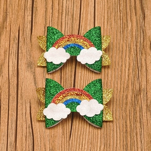 Macro shot of glittery rainbow cloud hair clips on wooden background for St. Patrick's Day
