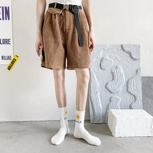 Detail of dark brown corduroy shorts featuring an elastic waist and black webbed belt