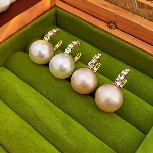 Elegant gold-tone hoop earrings set with lustrous white pearls and sparkling zircons