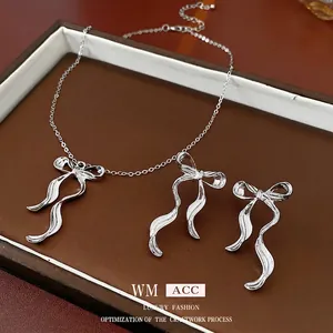Silver bow knot jewelry set including necklace and earrings displayed on a gift tray