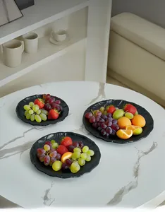 Close-up of black rippled metal tray sets with matte finish holding fresh seasonal fruits
