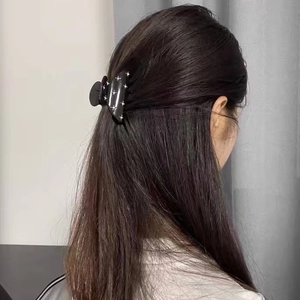 Detailed back view of a black star-studded claw clip holding a half-up hairstyle