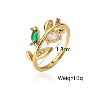 Macro detail of leaf-shaped gold ring with green zircons and size markings of 1.8cm