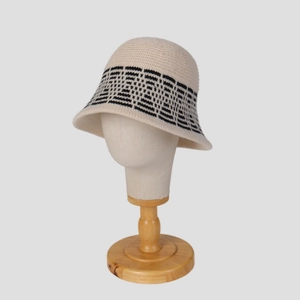 Detailed knit texture of beige bucket hat with black geometric pattern on mannequin