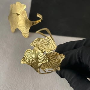 Macro shot of golden ginkgo leaf cuff bracelet showing realistic plant vein textures