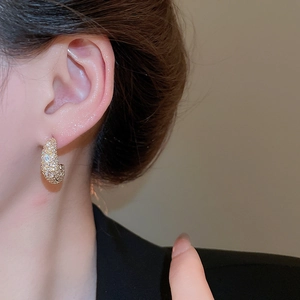 Detail view of crescent moon stud earrings in gold with pavé-set shimmering cubic zirconia