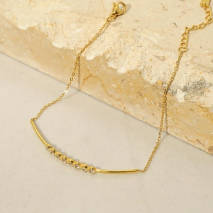 Macro detail of 18k gold plated bracelet with zircon stones on stone background