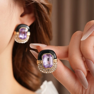 Detail of vintage square gold earrings with purple gemstone and pavé rhinestones