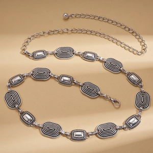 Detail of vintage silver metal waist chain with embossed geometric leaf patterns and clasp