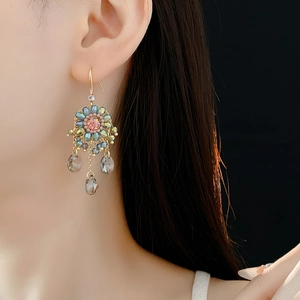 Detail view of ethnic boho earrings with pink beads and grey teardrop crystal tassels
