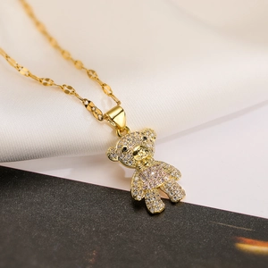 Detailed macro view of a gold-plated bear pendant set with pink and white cubic zirconia stones