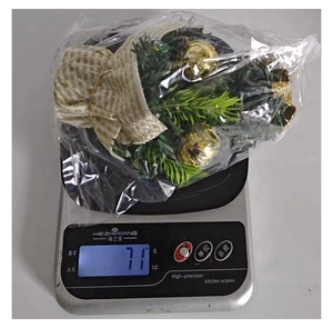 Mini Christmas tree ornament weight check showing 71g on scale for holiday decoration