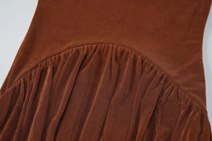 Close-up of caramel brown ribbed knit dress featuring intricate ruched seam detail
