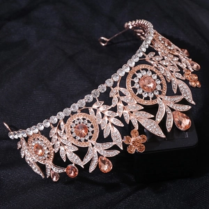 Close-up of rose gold bridal crown featuring sparkling rhinestones and peach gemstones