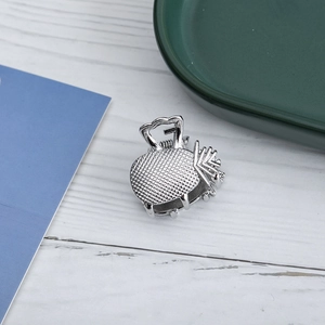 Detailed view of small silver metal hair claw clip with checkered texture and hollow design