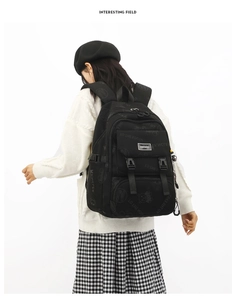 Close-up of black nylon backpack featuring cute bear patterns and multiple utility pockets