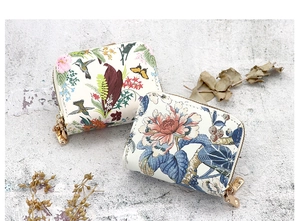 Detail view of two floral double-zipper card holder wallets with botanical patterns