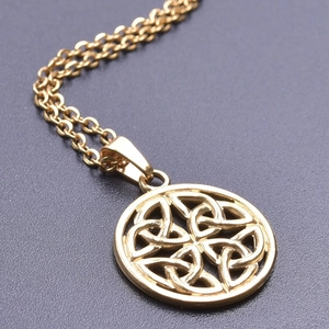 Vue macro d'un pendentif en acier inoxydable doré avec motif nœud celtique et chaîne O