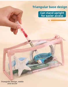 Detail of pink zipper on clear PVC pencil case showing stable triangular base structure