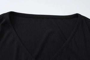 Detail von V-Ausschnitt und Rippstrick-Textur bei einem schwarzen langärmligen Cardigan