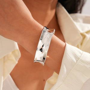 Close-up of minimalist silver wide open cuff bracelet with polished mirror finish for women