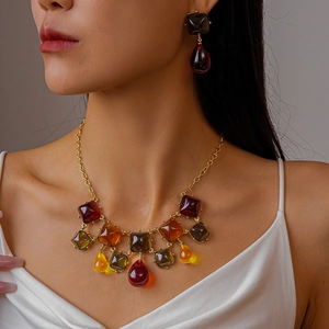 Gros plan sur le collier à pendentifs géométriques en résine et chaîne dorée