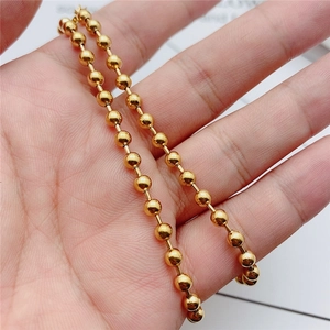 Minimalist gold titanium steel bead ball chain necklace held to show detailed texture