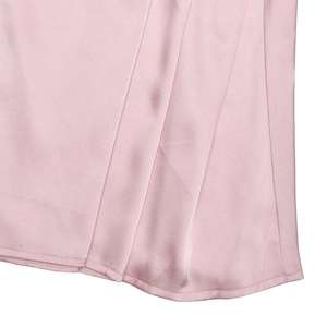 Detail shot of the pink silk satin dress hem showing the smooth glossy fabric and stitching