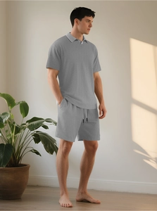 Dettaglio del set polo grigio da uomo con trama a nido d'ape e pantaloncini con coulisse