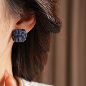 Close-up of model wearing square cushion-cut blue zircon pavé stud earrings in silver