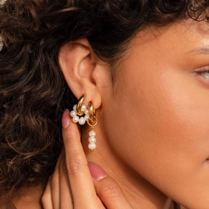 Detail of 18k gold plated stainless steel earrings with natural freshwater pearls on model