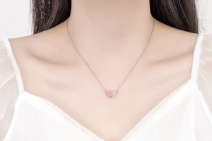 Detail of pink and white heart-shaped pendant necklace worn by a fashion model