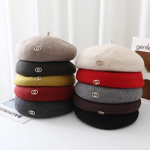 Detailed pile of woolen beret hats in multiple colors featuring metal double-ring buckle